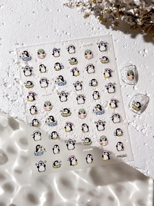 Détail des autocollants pour ongles pingouin en relief 3D sur une surface en pierre