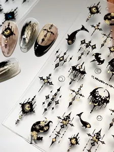 Macro detail of Gothic nail stickers featuring black and gold crosses and moon patterns