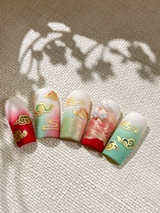 Detail of luxury Chinese style press-on nails with 3D gold embossed clouds and pearls