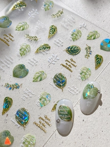 Detail of 3D embossed leaf nail stickers with gold foil accents and iridescent glitter