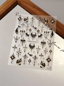 Detailed view of Gothic black and gold nail art stickers with moon and cross patterns
