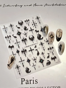 Macro view showing black gothic nail stickers with cross and bat motifs on nail tips