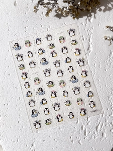 Vue macro de stickers d'ongles manchots mignons avec diverses poses sur fond texturé