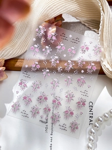 Detail view of 3D embossed pink rose nail stickers with bows on floral background