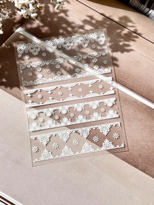 Macro detail of white embossed lace nail stickers with floral patterns on sheet YT4119
