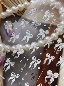 Macro shot of 3D aurora white ribbon bow nail stickers with shell luster, model YT6512