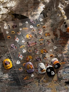 Detailed view of Halloween nail stickers with pumpkins and ghosts on colored nails