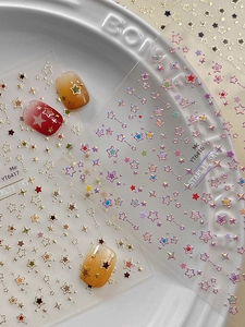 Detail of laser star nail art stickers and gradient effects on applied nails