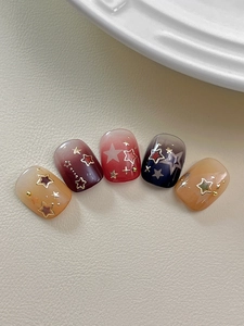 Macro view of gradient press-on nails with golden stars and glitter studs on leather