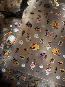 Detail of Halloween nail stickers featuring pumpkins, ghosts and witches on a festive background