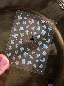 Detail of Halloween nail stickers featuring ghosts, pumpkins and castles in silver and orange