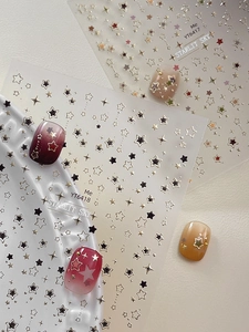 Detail of Starlit Sky star-themed nail stickers with metallic gold stars and dots