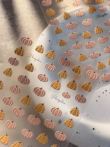 Detailed view of Halloween pumpkin nail stickers with embossed textures and gold accents