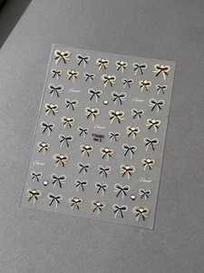 Detailed view of sweet bow nail stickers with pearls and gold foil accents in YT6085 style