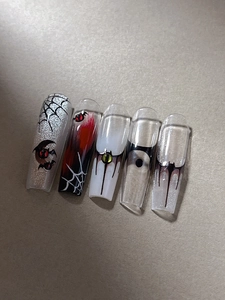 Detailed view of Halloween press-on nails with spider webs and bat silhouettes