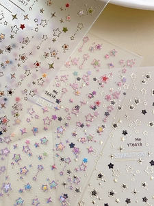 Macro view of iridescent star nail art stickers with laser silver and colorful glitter patterns