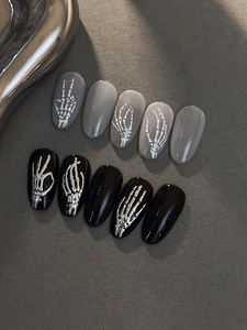 Detailed view of Halloween press-on nails featuring silver metal 3D skull hands