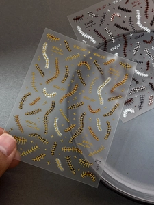 Macro shot of YT6114 gold fishbone nail stickers with punk style stitch patterns