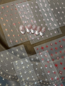 Macro shot of glittery star nail stickers with rhinestones in gold and silver