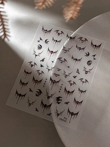 Macro detail of gothic Halloween bat nail art decals with dark moon and star patterns