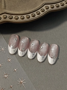 Detailed view of French pink gradient press-on nails with silver stars and rhinestones