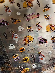 Macro detail of 3D embossed Halloween nail stickers featuring witches and pumpkins