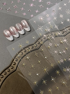 Macro shot of glitter starburst nail stickers with 3D metallic gold and silver star designs