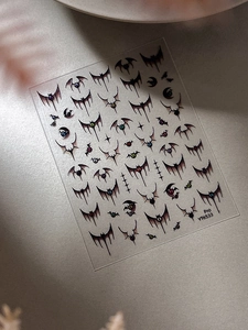 Detail of Halloween bat wing nail stickers with colorful pupils and crescent moon shapes