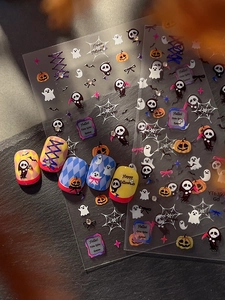 Macro shot of Halloween nail stickers with 3D reaper, pumpkin, and ghost embossed designs
