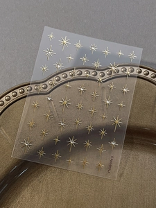 Detail of YT6489 gold star nail stickers with rhinestones on a vintage bronze tray