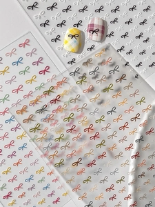 Detail view of embossed 3D bow nail art stickers with various color options and application