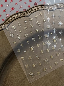Macro detail of star-shaped nail art stickers with metallic finish and rhinestones