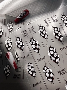 Detail of gothic Halloween nail stickers with spooky faces and cracked artistic patterns