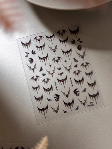 Macro detail of gothic bat and moon nail art stickers with ultra-thin texture