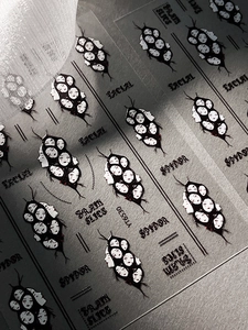 Detail of gothic Halloween nail stickers featuring dark human-faced spider patterns
