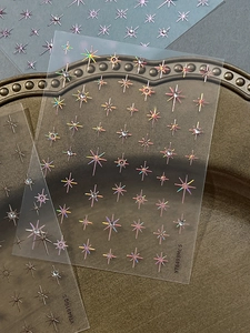 Macro detail of laser holographic star nail stickers with sparkling crystal rhinestones