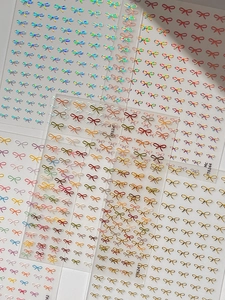 Detailed view of 3D embossed bow nail stickers with holographic and gold accents
