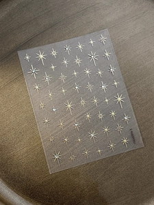 Detailed view of gold starburst nail art stickers with sparkly rhinestones, style YT6489