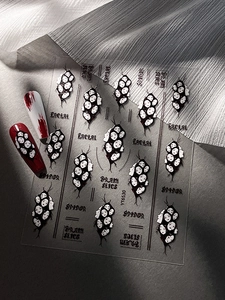 Detail of gothic Halloween nail art stickers featuring spider webs and facial patterns