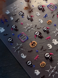 Macro detail of 3D embossed Halloween nail stickers with Grim Reaper and ghost motifs