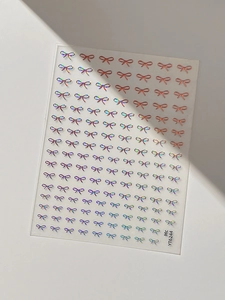 Detailed sheet of 3D embossed bow nail stickers in laser aurora and rose gold colors