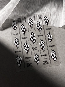 Macro shot of Gothic spider face nail art stickers with black crackle and red accents