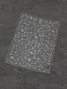 Macro detail of silver constellation nail art stickers with metallic star sign designs