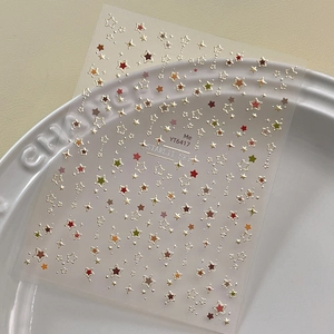 Colorful star-themed nail art stickers YT6417 with metallic edges on a ceramic plate