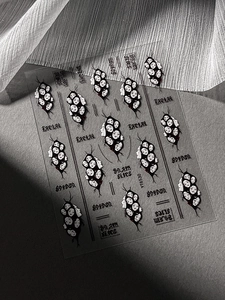 Macro shot of Gothic nail stickers with black horror face patterns and Spider text detail