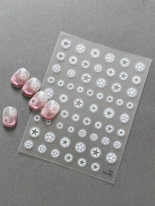 Close-up of starry nail art stickers with pink gradient nails and star pattern details