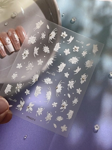 Macro shot of 3D embossed white floral and butterfly nail stickers with pearls YT6323