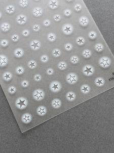 Macro shot of silver star nail art stickers with solid and hollow star patterns