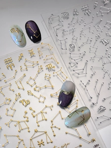 Macro detail of metallic gold and silver star sign nail art stickers with zodiac patterns
