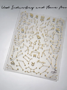 Macro shot of gold constellation nail art stickers with star sign patterns and metallic lines